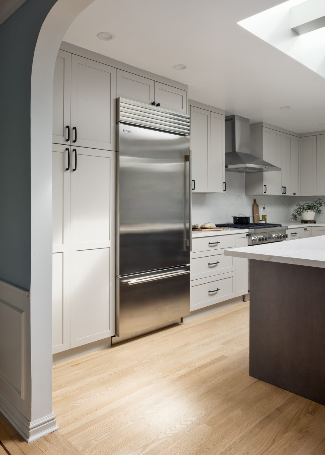 Arcadia kitchen with stainless refrigerator and archway entry
