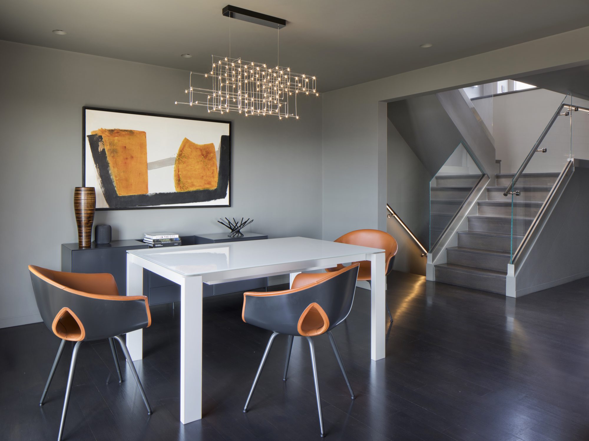 Biltmore dining area with white table, leather chairs, and a linear chandelier