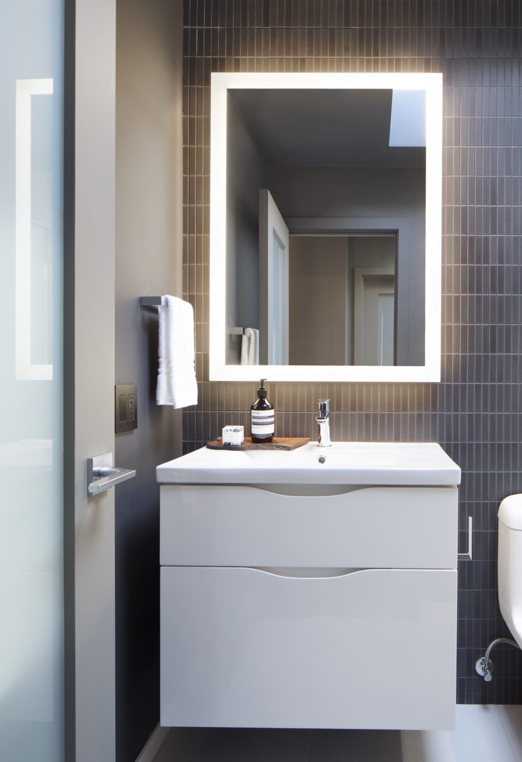 Biltmore powder room with white floating vanity and dark tile