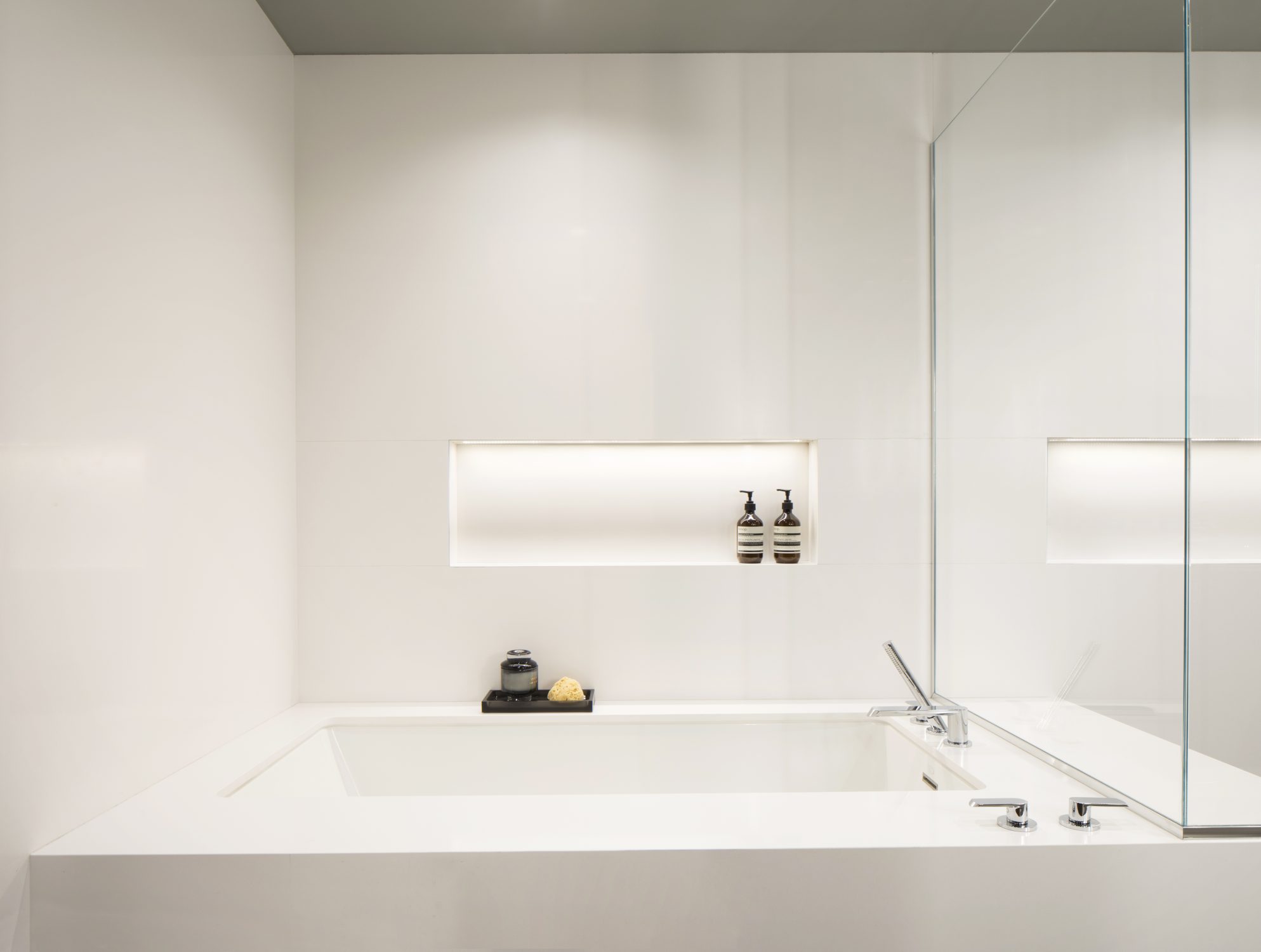 Biltmore bathroom with a white soaking tub and lit niche