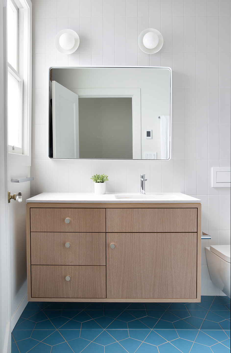 Chandler bathroom with a floating oak double-drawer vanity and blue geometric floor tile