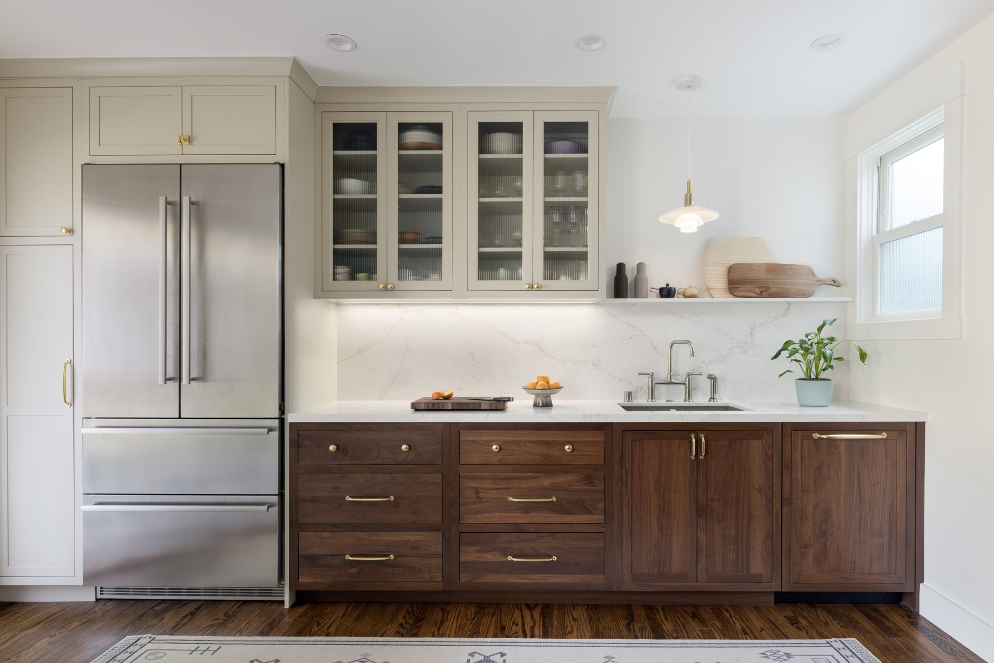 Paradise Valley kitchen with walnut cabinetry, glass-front uppers, and marble backsplash