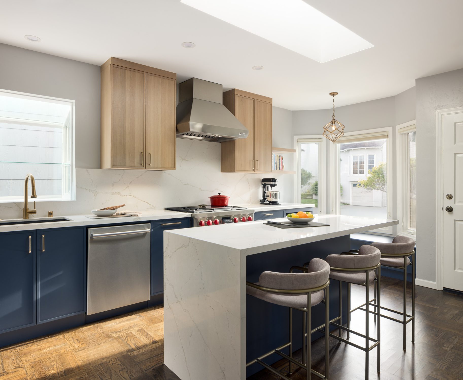 Scottsdale kitchen with navy lower cabinets, oak uppers, and a quartz waterfall island