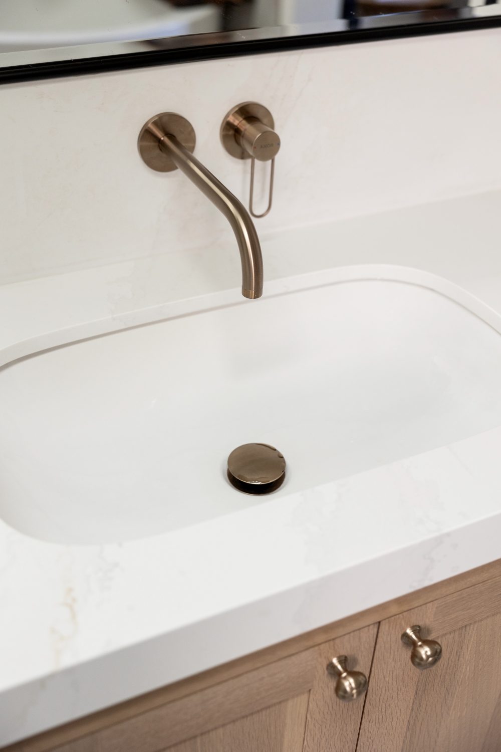 Tempe modern bronze wall faucet over a white quartz sink