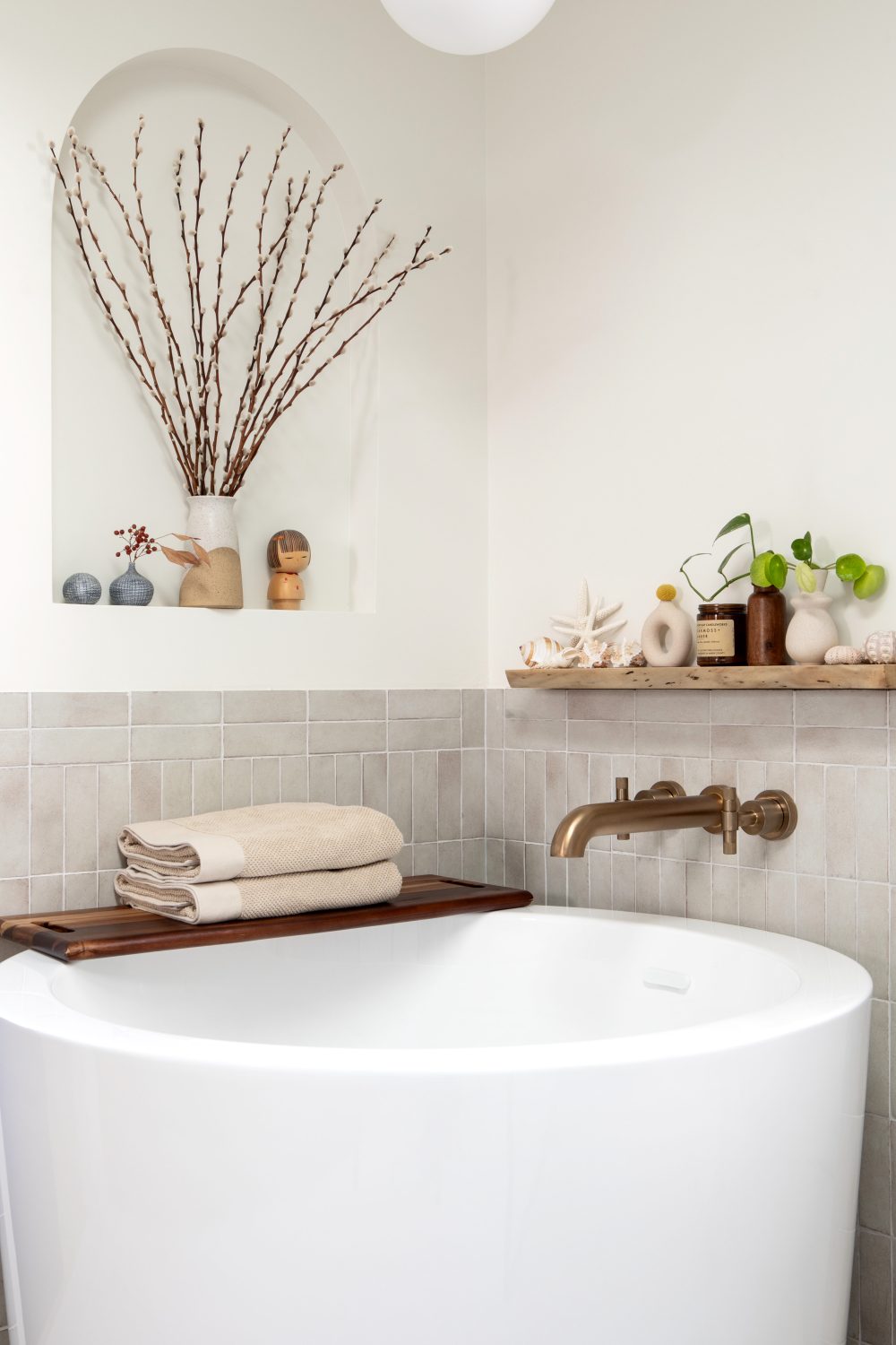 Tempe modern soaking tub with arched niche and bronze filler